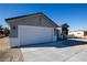 New single-story home with gray exterior, white garage door, and arched entryway at 3960 Dart Dr, Pahrump, NV 89060