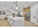 Large kitchen island with white cabinets, quartz countertop and stainless steel refrigerator at 517 Annet St, Henderson, NV 89052