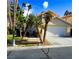 Tan two-story house with a tile roof, palm trees, and a grassy yard at 5508 Big Sky, Las Vegas, NV 89149