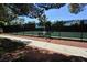 Tennis court with perimeter fencing, a bench, and a paved walkway at 5508 Big Sky, Las Vegas, NV 89149