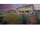 Spacious back yard featuring lush lawn, gravel landscaping, a covered patio, and a two-story house at 553 Sinfold Park St, Las Vegas, NV 89148