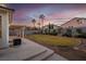 Scenic backyard with a lush lawn, covered patio, and swaying palm trees, offering serene outdoor space at 553 Sinfold Park St, Las Vegas, NV 89148