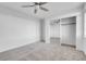 Neutral carpeted bedroom featuring a ceiling fan and sliding mirrored closet doors at 553 Sinfold Park St, Las Vegas, NV 89148