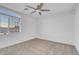 A carpeted bedroom with a ceiling fan and a arched window offering a view of the horizon at 553 Sinfold Park St, Las Vegas, NV 89148