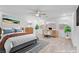 Bright bedroom boasts a ceiling fan, two windows, a stylish desk, and a comfortable bed with modern decor at 553 Sinfold Park St, Las Vegas, NV 89148