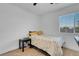 A small carpeted bedroom with a twin bed, small side table, and a large window at 553 Sinfold Park St, Las Vegas, NV 89148