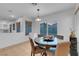 Bright dining area with large windows, an elegant light fixture, and direct access to the kitchen at 553 Sinfold Park St, Las Vegas, NV 89148