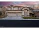 Two-story tan home with a two-car garage and well-maintained landscaping at 553 Sinfold Park St, Las Vegas, NV 89148