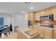 Kitchen featuring wooden cabinets, backsplash, modern appliances, and an island with tile countertop at 553 Sinfold Park St, Las Vegas, NV 89148