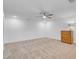 Neutral bedroom with a ceiling fan, carpeted floors, and a wooden dresser with lamp providing soft lighting at 553 Sinfold Park St, Las Vegas, NV 89148