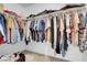 A filled walk-in closet with clothing hanging on rods at 553 Sinfold Park St, Las Vegas, NV 89148