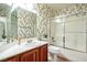 Bathroom with leafy wallpaper and shower/tub combo at 575 Dusty Palms Ln, Henderson, NV 89052