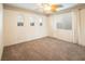 Cozy bedroom with bright windows, ceiling fan, and neutral carpeting at 575 Dusty Palms Ln, Henderson, NV 89052