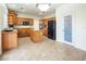 Open kitchen with island, wood cabinets, and tile floors at 575 Dusty Palms Ln, Henderson, NV 89052