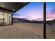 Covered patio overlooks expansive backyard with city views at sunset at 577 Overlook Rim Dr, Henderson, NV 89012