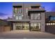 Modern home exterior with large windows and balcony at dusk at 577 Overlook Rim Dr, Henderson, NV 89012