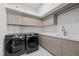 Modern laundry room with washer, dryer, and ample storage at 577 Overlook Rim Dr, Henderson, NV 89012