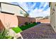 Landscaped backyard with artificial turf and brick patio at 6046 Castle Gardens Ave, Las Vegas, NV 89130