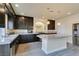 Modern kitchen with dark cabinetry, granite counters, and a large island at 6050 Belvedere Canyon Ave, Las Vegas, NV 89139