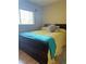 Cozy bedroom with a double bed, yellow bedding, and teal throw blanket at 659 Glenwood Ln, Henderson, NV 89002