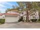 Two-story house with Spanish tile roof, attached garage, and landscaping at 6973 Emerald Springs Ln, Las Vegas, NV 89113