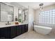 Modern bathroom with a freestanding tub, double vanity, and a large mirror at 7 Summit Walk Trl, Henderson, NV 89052