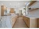 Long view of a modern kitchen with marble island and oak cabinets at 7 Summit Walk Trl, Henderson, NV 89052