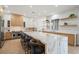 Large kitchen island with marble countertops, stainless steel appliances, and light wood cabinets at 7 Summit Walk Trl, Henderson, NV 89052