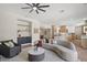 Living room with curved sofa and adjacent kitchen at 7 Summit Walk Trl, Henderson, NV 89052