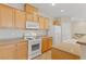 Modern kitchen with light wood cabinets, white appliances, and a breakfast bar at 7322 Fools Gold St # 101, Las Vegas, NV 89149