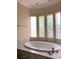 Relaxing bathroom with an oval soaking tub and large windows at 768 Tozzetti Ln, Henderson, NV 89012