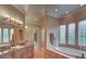 Elegant bathroom featuring a large soaking tub, granite vanity, and glass block windows at 768 Tozzetti Ln, Henderson, NV 89012