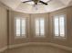 Bright bedroom featuring three windows with plantation shutters and a ceiling fan at 768 Tozzetti Ln, Henderson, NV 89012