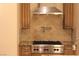 Modern kitchen with gas cooktop, custom cabinetry, and diamond-pattern backsplash at 768 Tozzetti Ln, Henderson, NV 89012