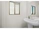 Clean bathroom with pedestal sink and large mirror at 7777 Tempest Sol Ave, Las Vegas, NV 89113