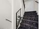 Modern staircase with metal railing and dark carpeting at 7777 Tempest Sol Ave, Las Vegas, NV 89113