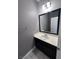 Modern bathroom with dark vanity, updated fixtures, and a large mirror at 8157 Lennox View Ln, Las Vegas, NV 89113