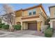 Tan two-story house with brown garage door and landscaping at 8477 Orly Ave, Las Vegas, NV 89143