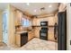 Kitchen with wood cabinets, black appliances, and granite countertops at 8477 Orly Ave, Las Vegas, NV 89143