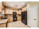 Kitchen with wood cabinets, black appliances, and granite countertops at 8477 Orly Ave, Las Vegas, NV 89143