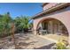 Charming covered back patio area with a stone fireplace and desert landscaping at 8490 Via De Bellasidra Ct, Las Vegas, NV 89123