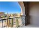 Balcony with stone pillar overlooking a quiet neighborhood street with mature trees and well-kept homes at 8490 Via De Bellasidra Ct, Las Vegas, NV 89123