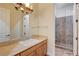 Bathroom featuring a glass-enclosed shower, travertine tile, neutral countertops, and a modern light fixture at 8490 Via De Bellasidra Ct, Las Vegas, NV 89123