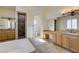 Well-lit bathroom features dual sinks, a soaking tub, and a walk-in shower with tile surround at 8490 Via De Bellasidra Ct, Las Vegas, NV 89123