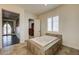 Bright bathroom featuring a tiled surround tub and large shuttered window at 8490 Via De Bellasidra Ct, Las Vegas, NV 89123