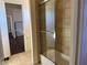 Bathroom with beige tile, shower/tub combo and view of bedroom at 8490 Via De Bellasidra Ct, Las Vegas, NV 89123