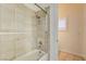 A neutral bathroom with a shower and bath combo, tiled walls, and tiled floors at 8490 Via De Bellasidra Ct, Las Vegas, NV 89123