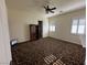 Bedroom with dark patterned carpet, ceiling fan and large window with shutters at 8490 Via De Bellasidra Ct, Las Vegas, NV 89123