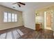 Spacious bedroom with wood floors, fan, plantation shutters, and en-suite bathroom at 8490 Via De Bellasidra Ct, Las Vegas, NV 89123