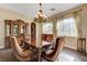 Elegant dining room with wood floors, stylish furniture, and natural light from the windows at 8490 Via De Bellasidra Ct, Las Vegas, NV 89123